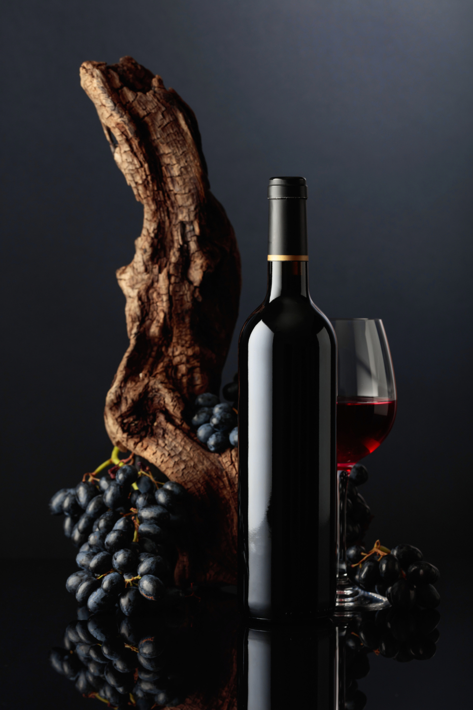 Vinflaska framvör druvor och träbit.